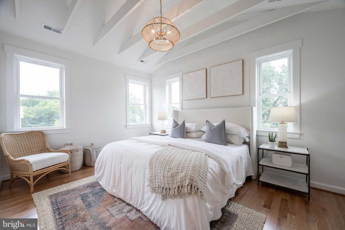 white bedroom with bed covered in white sheets