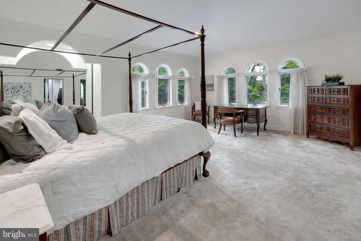 bedroom with carpet floors and arched windows