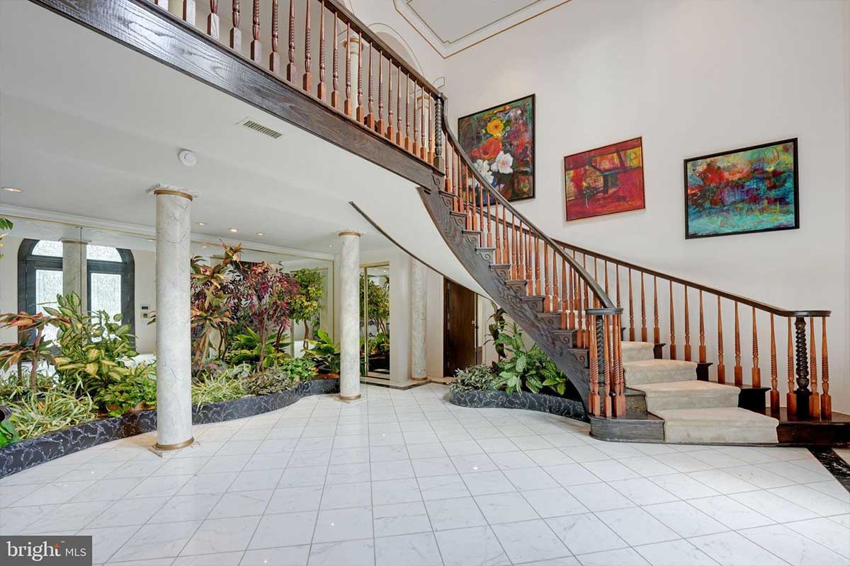 greeting foyer with curved staircase and area for plants