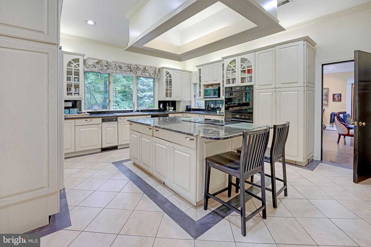 white kitchen with island and dark stone countertops