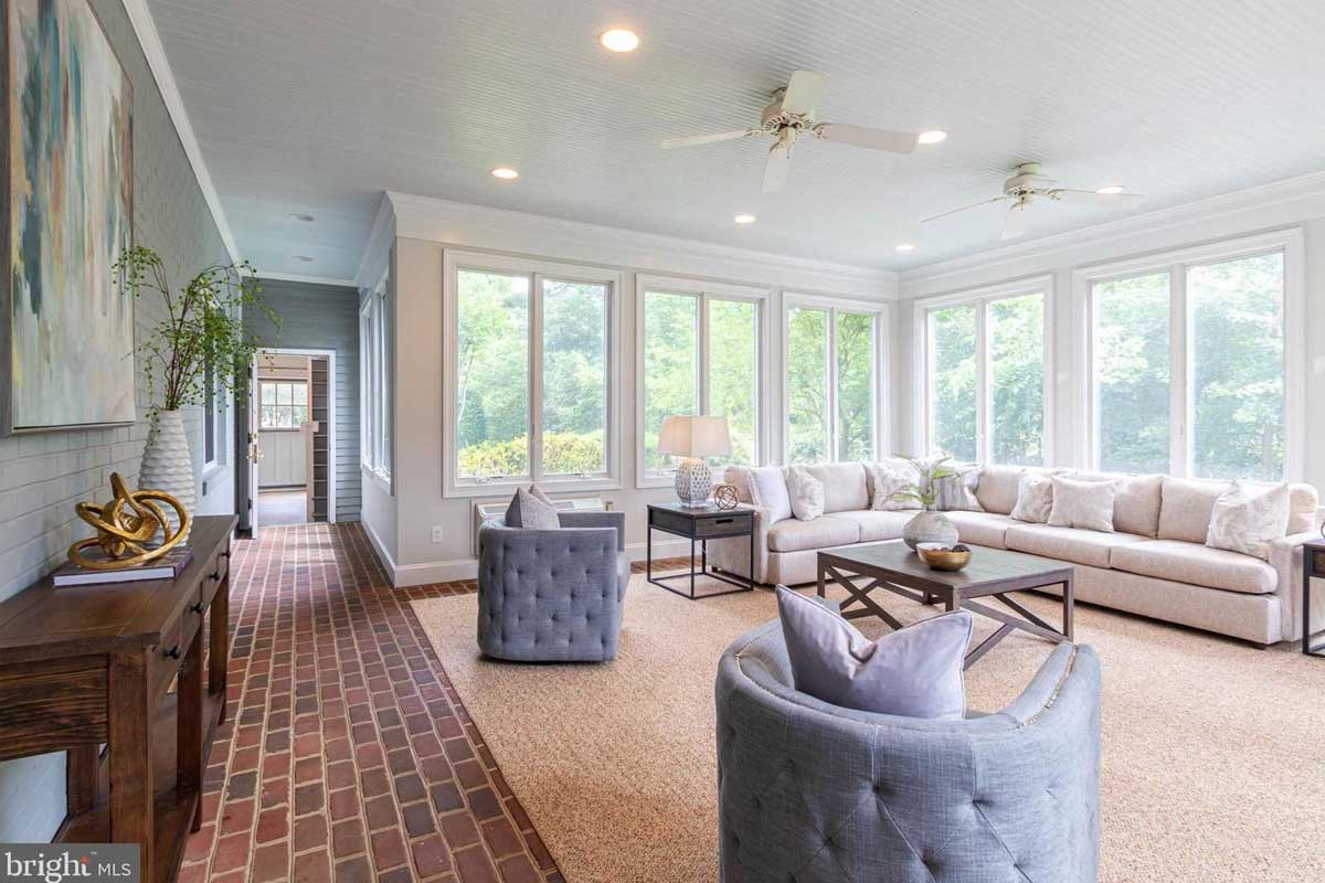 sunroom with white couch and ceiling fans