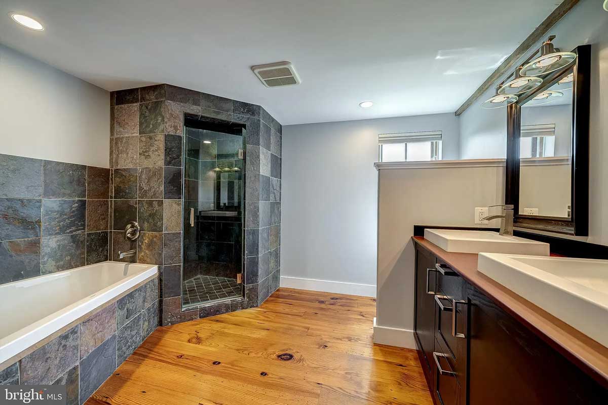 bathroom with stone tile backsplash and walk-in shower