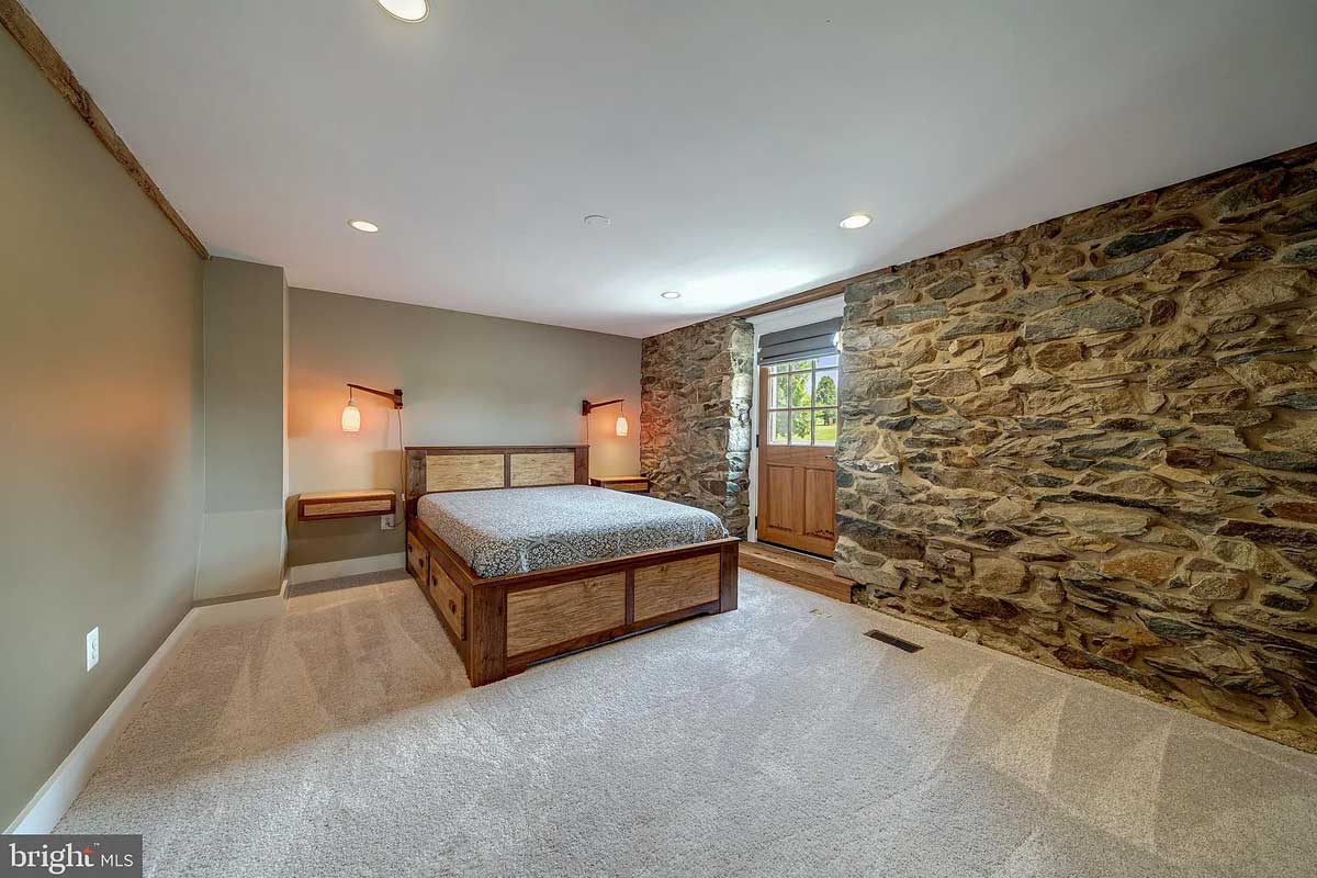 bedroom with stone wall and grey carpet