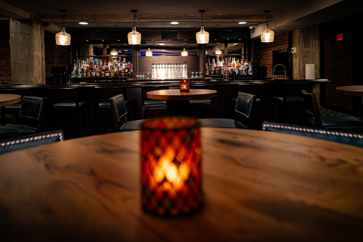 Bar with wood tables, low lighting, and candles