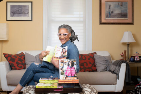 Carla Hall holding her cookbook