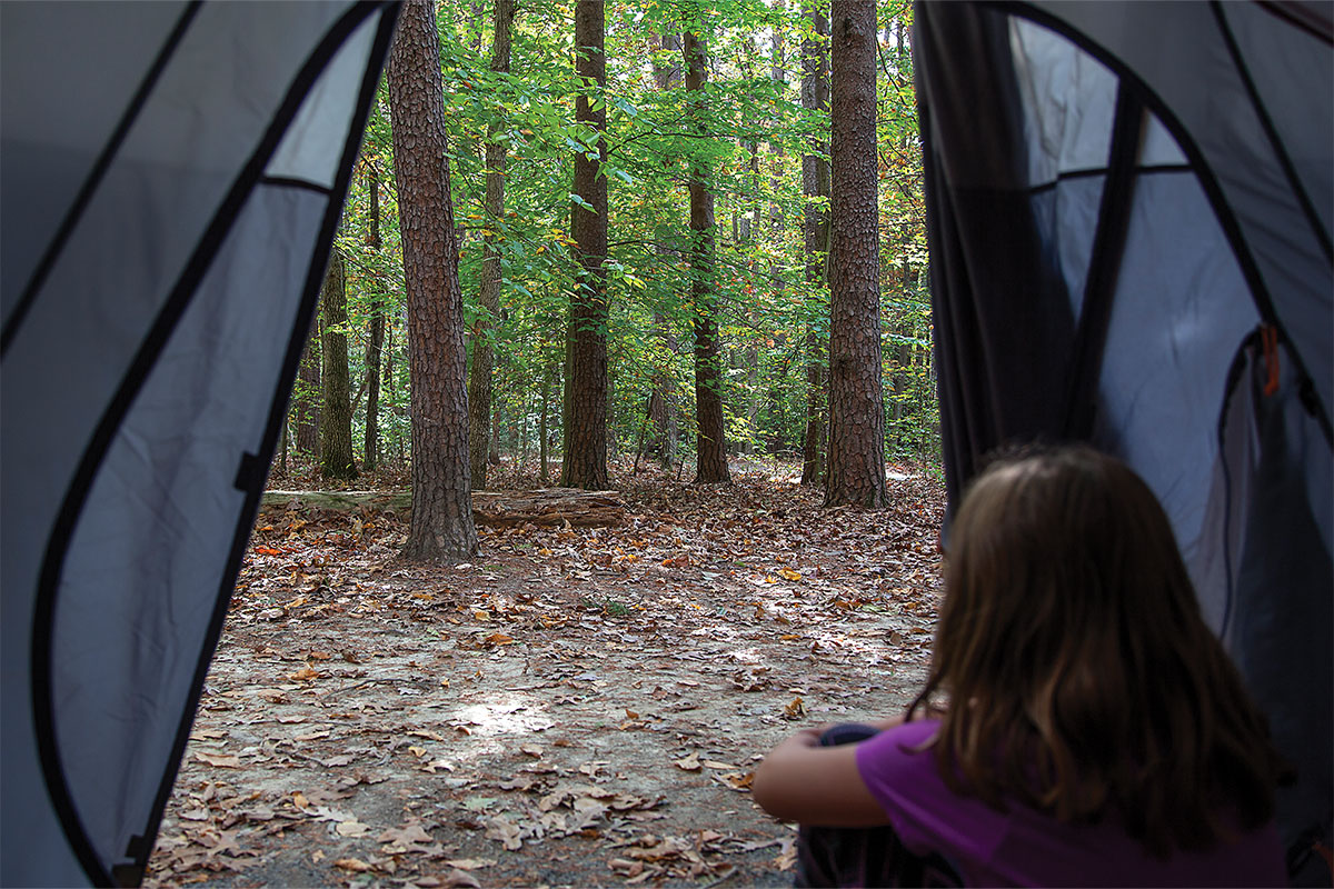 Girl looking out tent at Prince William Forest