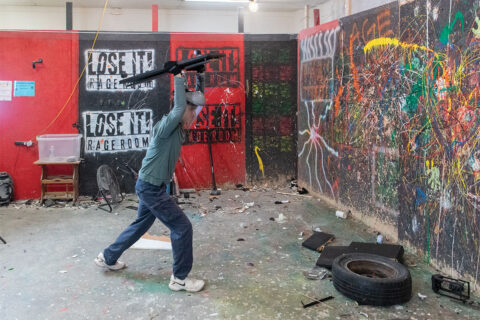 Person smashing things at Lose It Rage Room