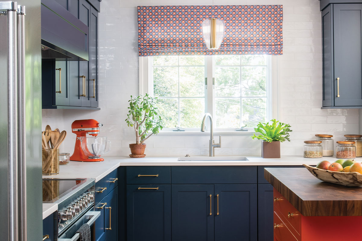 Kitchen with dark blue cabinets and orange accents