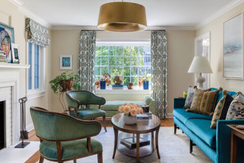 Living room with blue couch and colorful curatains