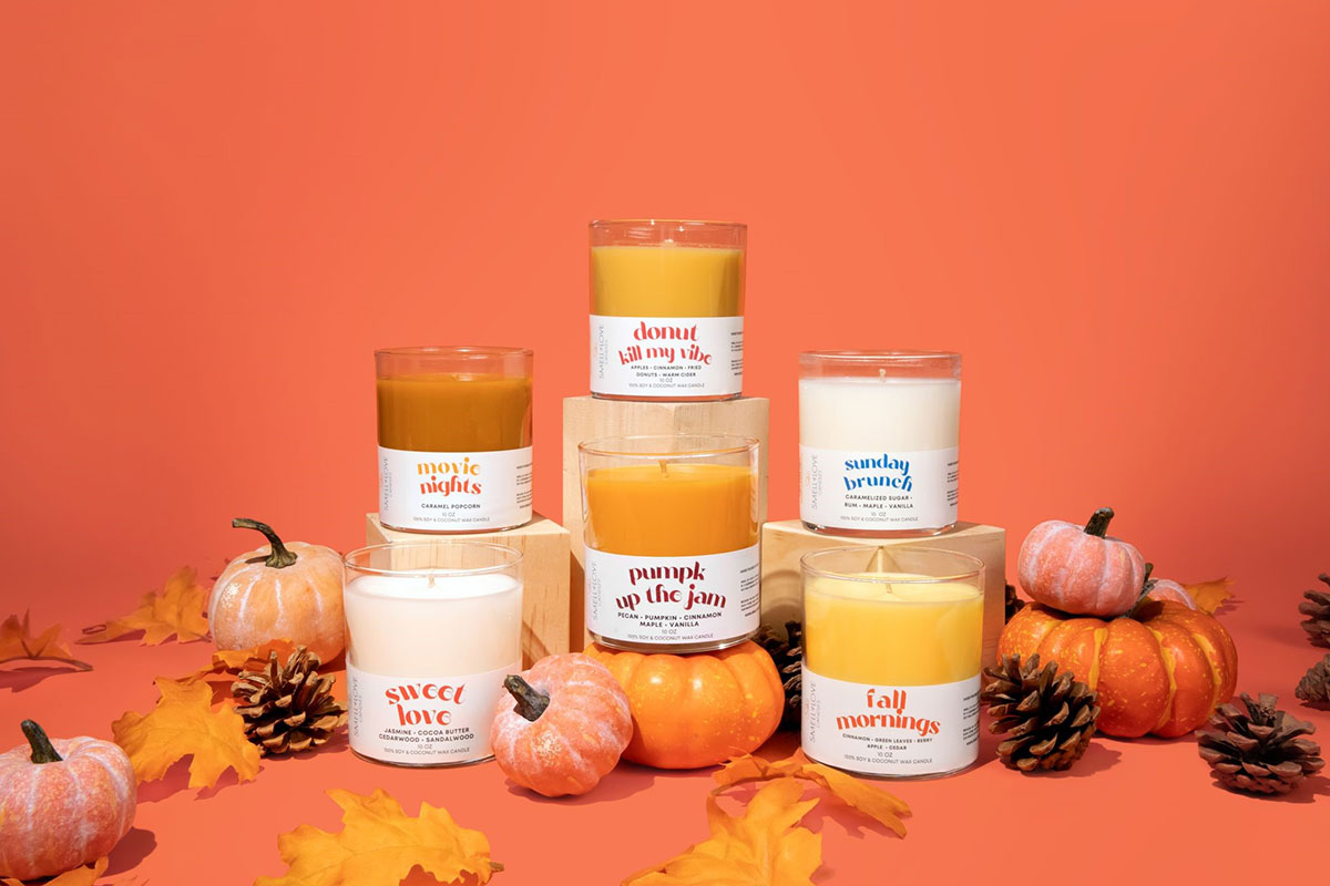 Six candles from Smell of Love Candles, surrounded by pumpkins and pinecones