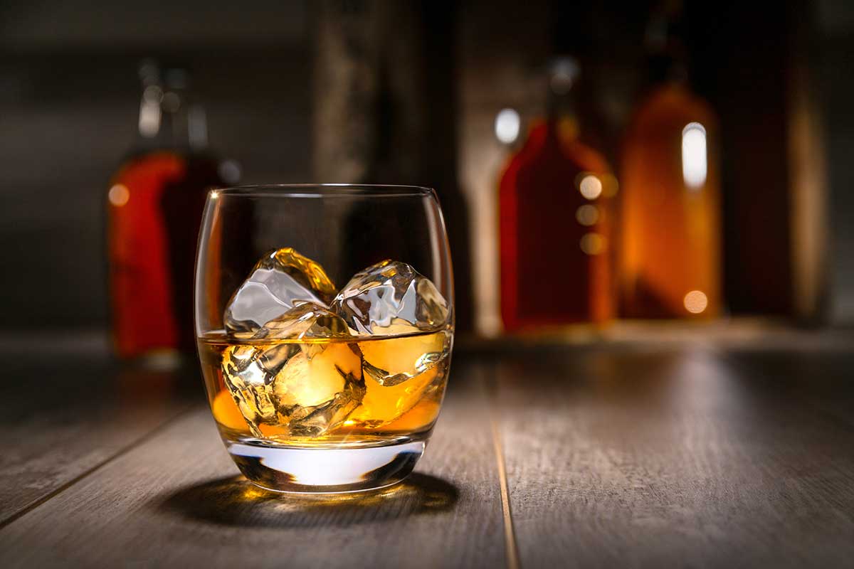 glass of bourbon on a bar