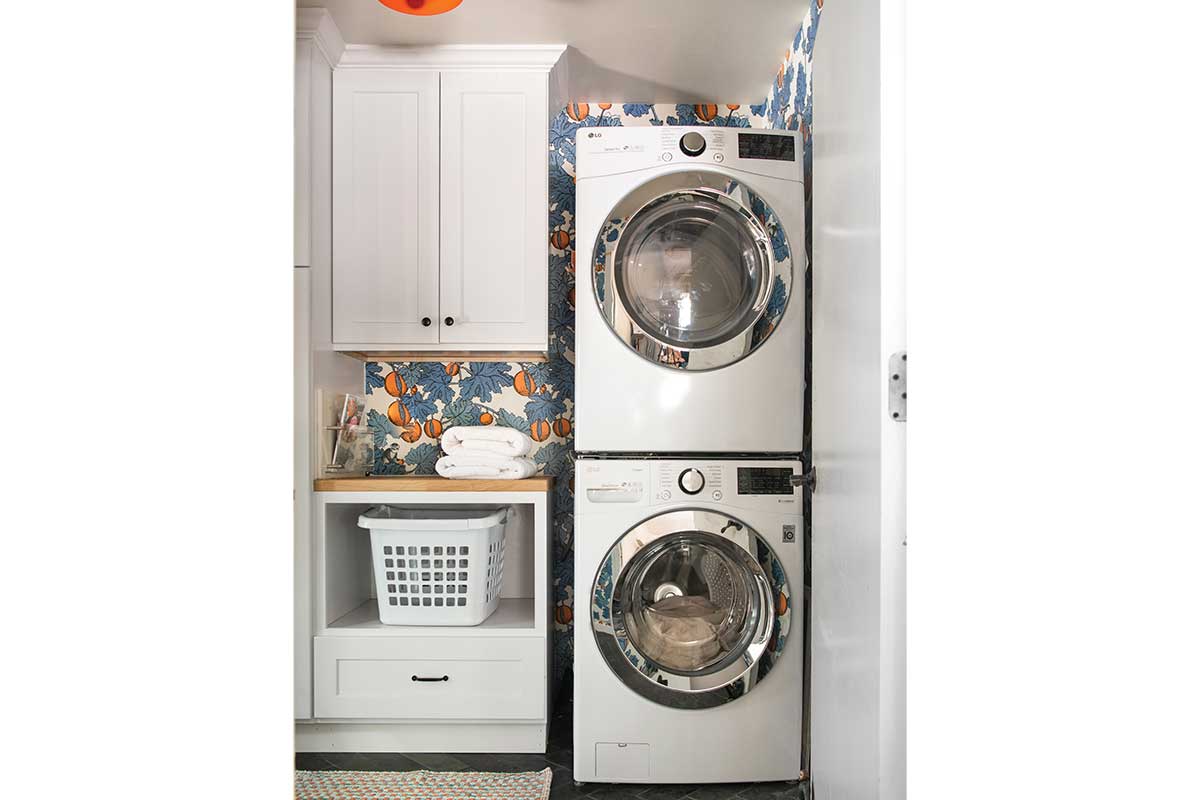 stacked dryer washing with patterned wallpaper wall