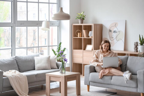 Woman sitting alone in apartment with laptop
