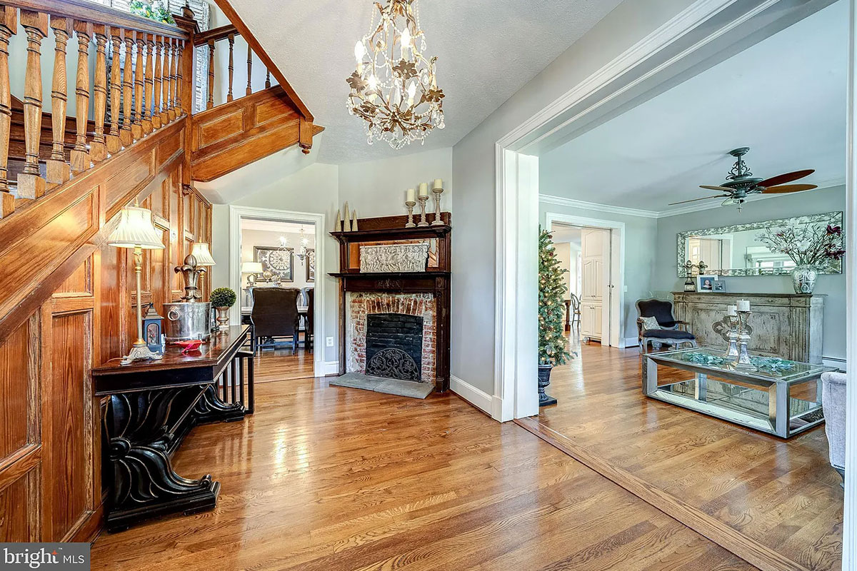 Entryway with brick fireplace and wood stairwell