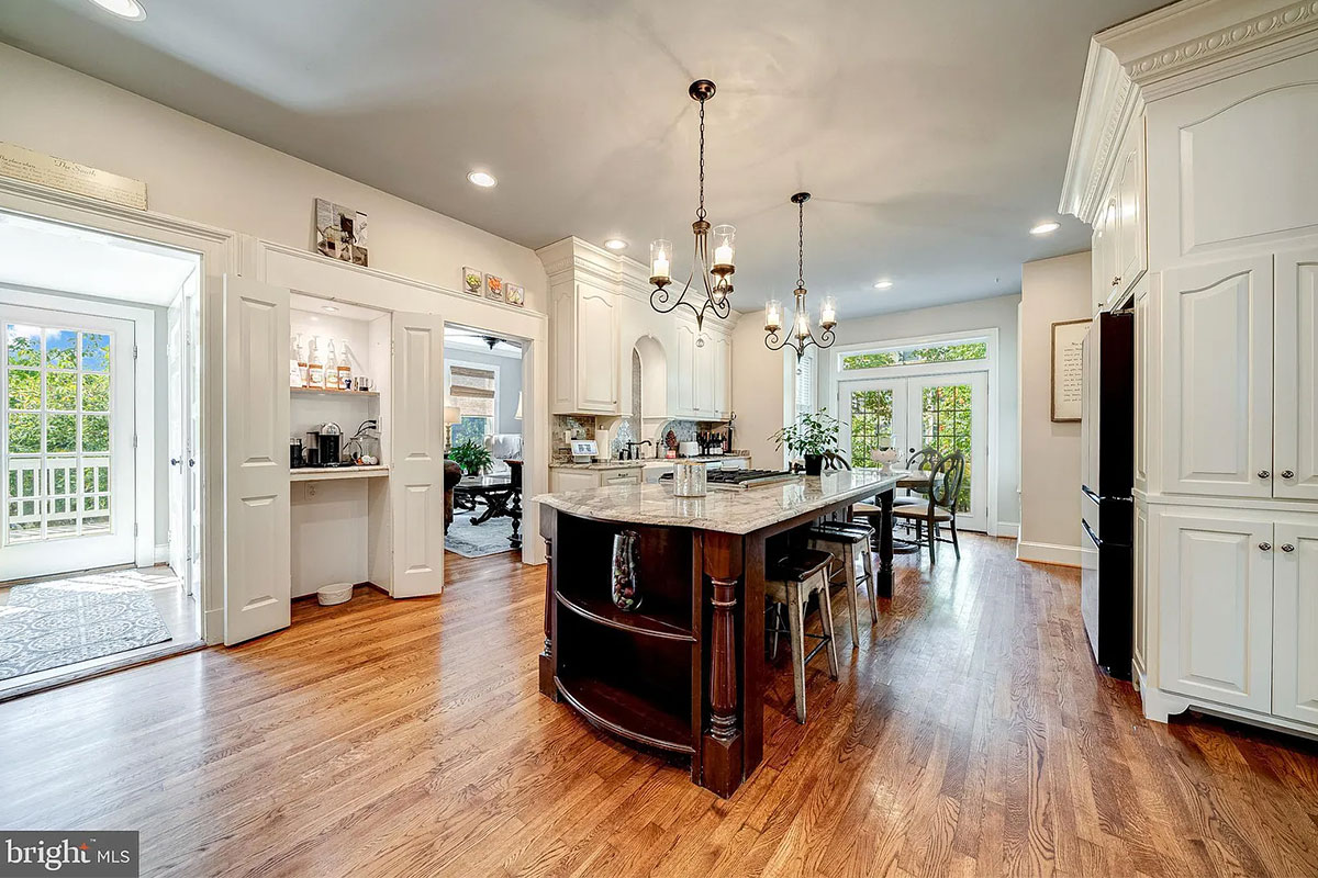 Kitchen with wood floors, wood island, and white cabinets
