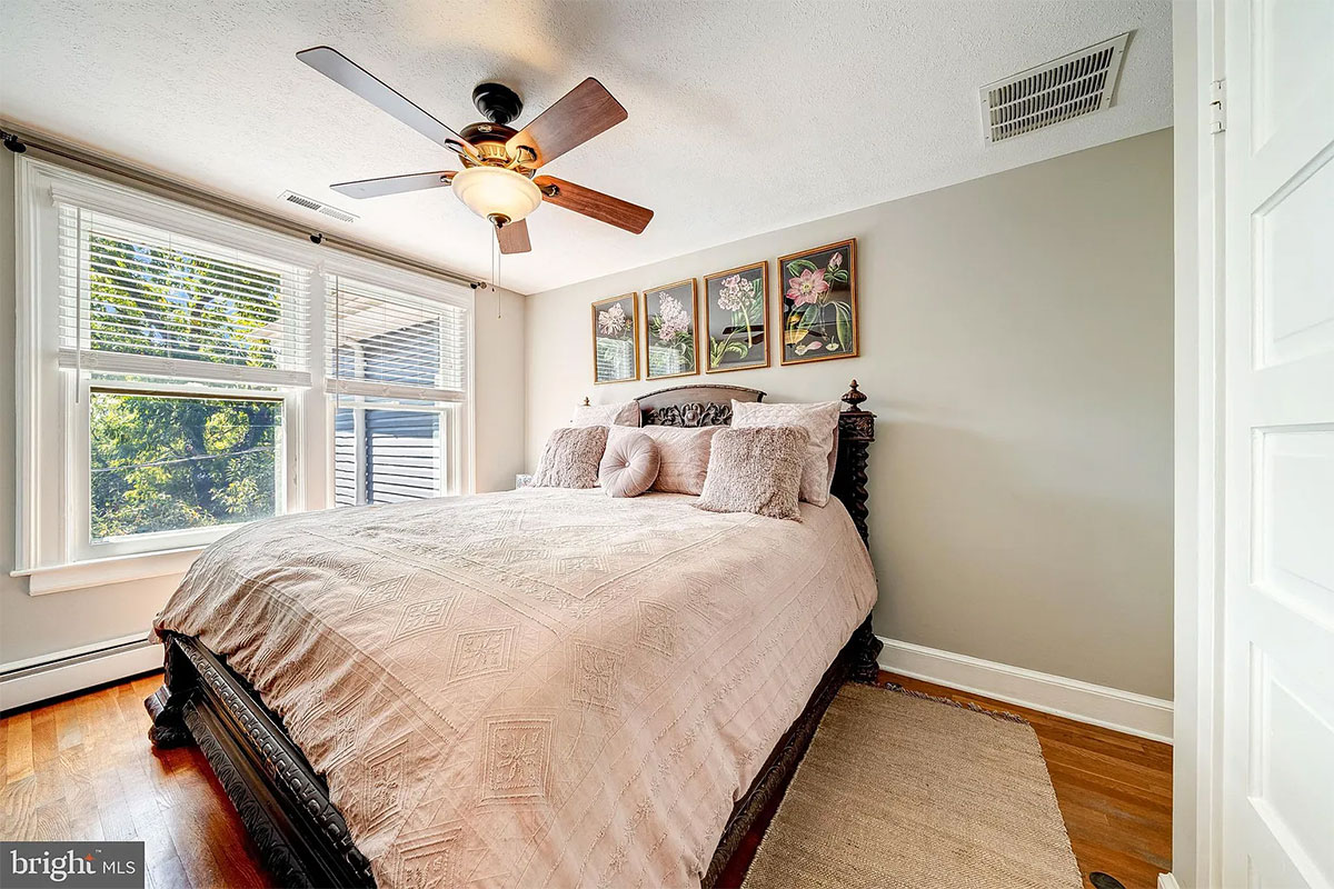 Bedroom with wood floors and two windows