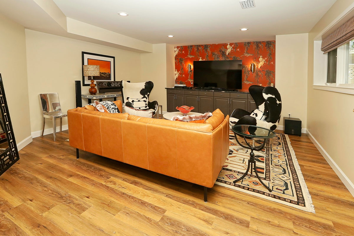 Living room with cow-printed chairs and bright red patterned wallpaper