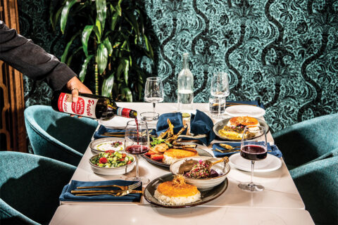 Table of food from Joon, including tahdig, lamb, and red wine