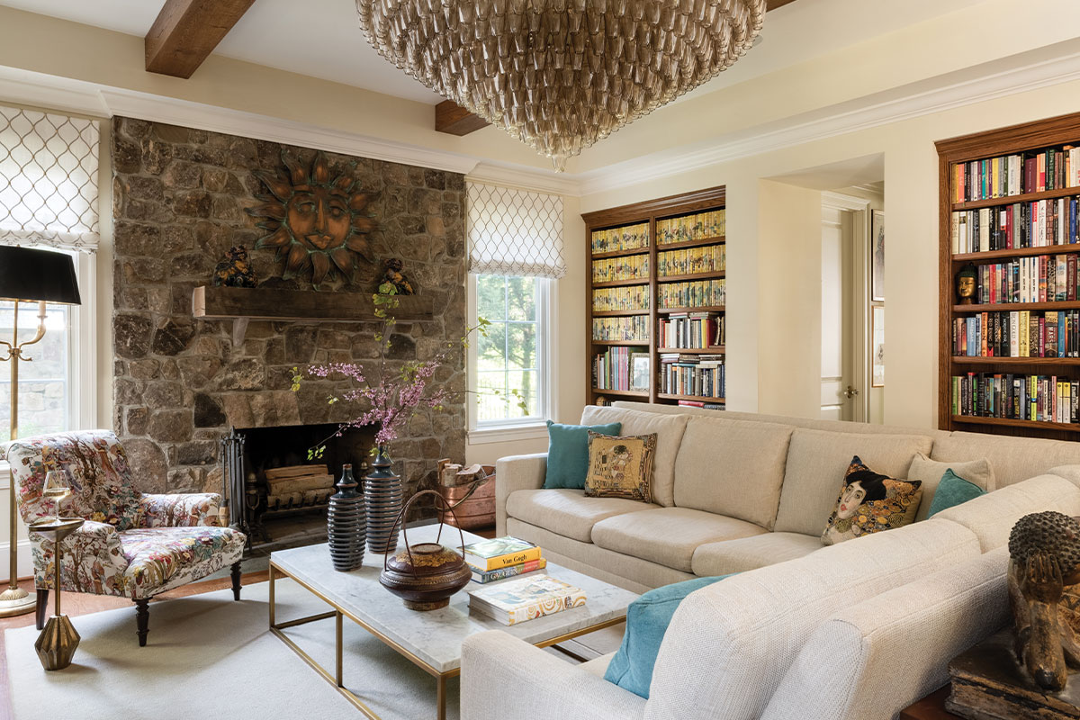 Living room with stone fireplace, bronze wall art, and art print pillows
