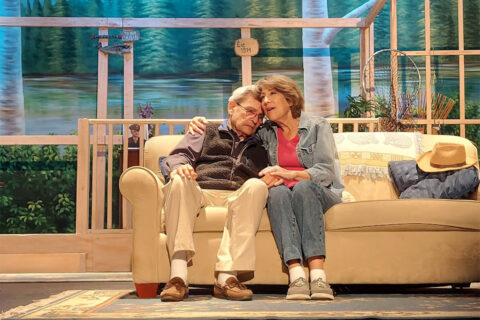 People sitting on couch on stage