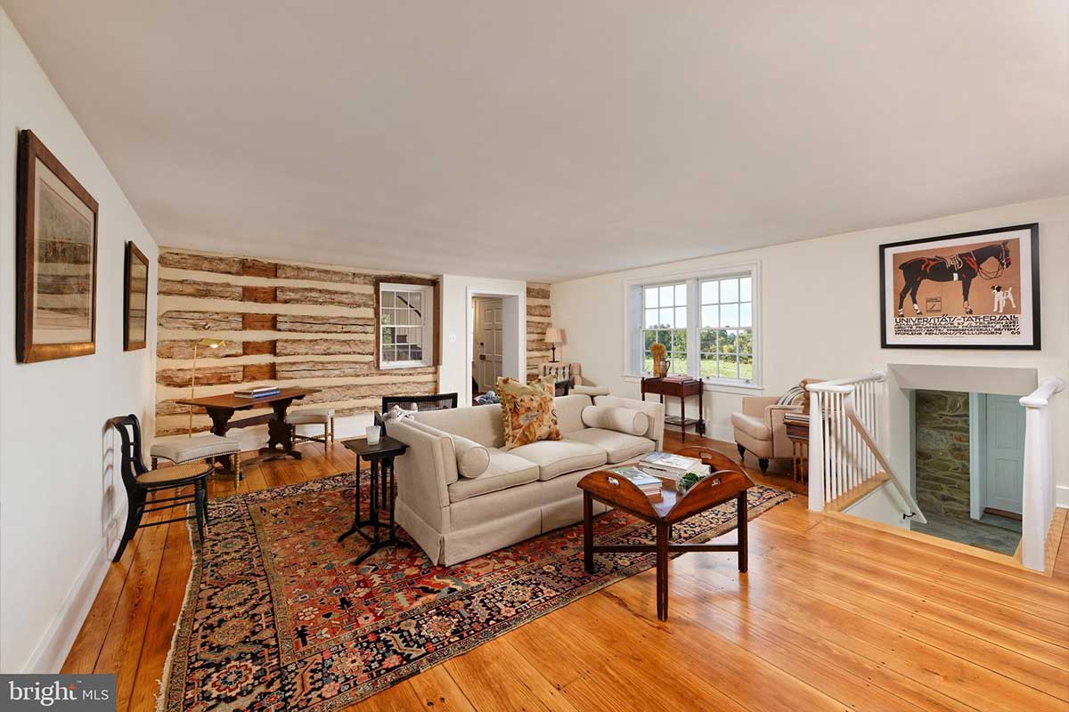 living room with log wall and hardwood floors