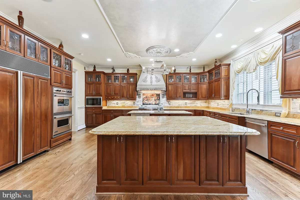 gourmet kitchen with two islands and dark wood cabinets