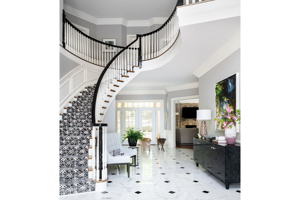 Foyer with large curved staircase and marble floors