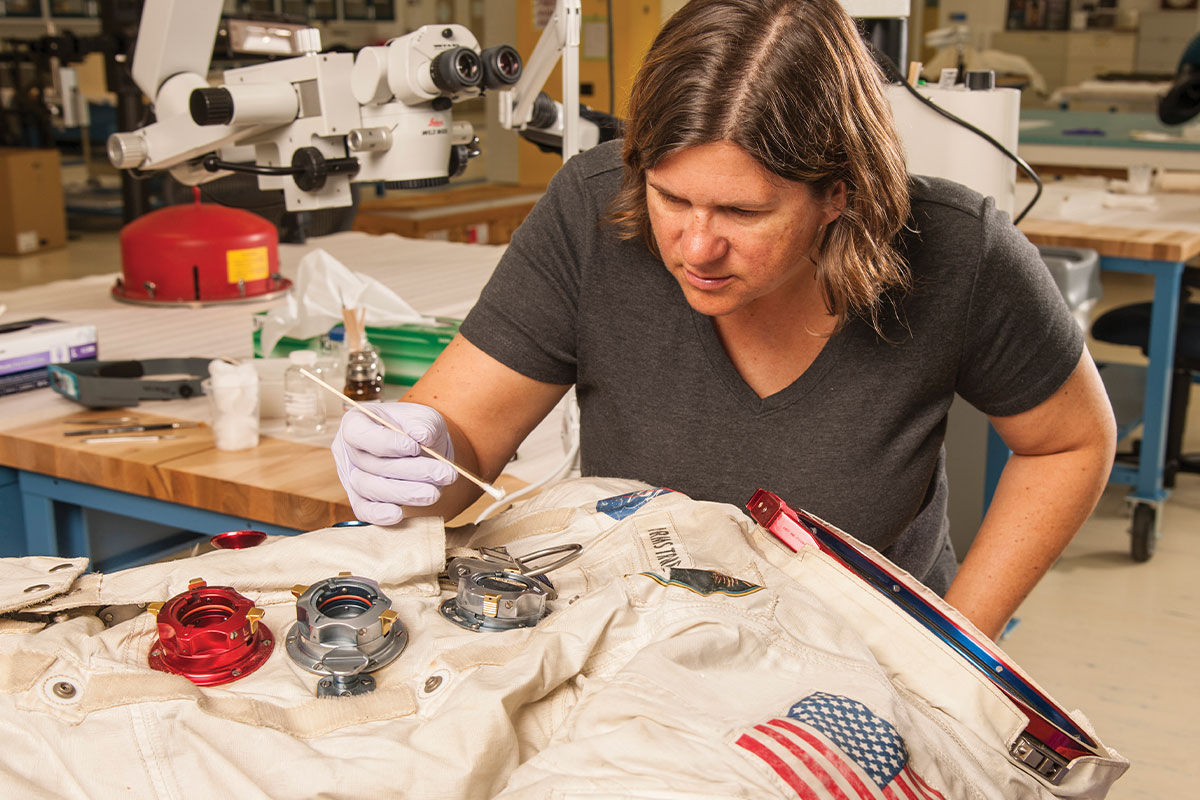 Conservator works on preserving a spacesuit