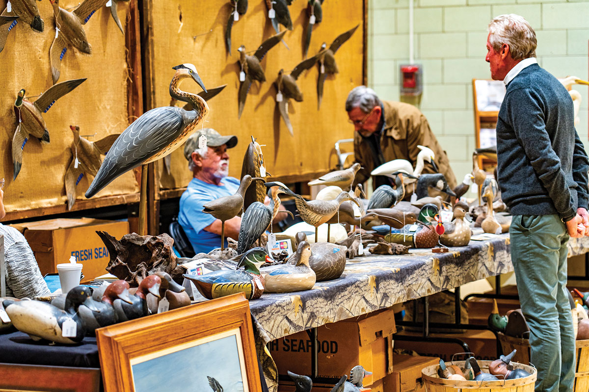 People looking at vintage decoys at Waterfowl Festival