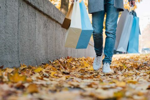 person walking with shopping bags during fall