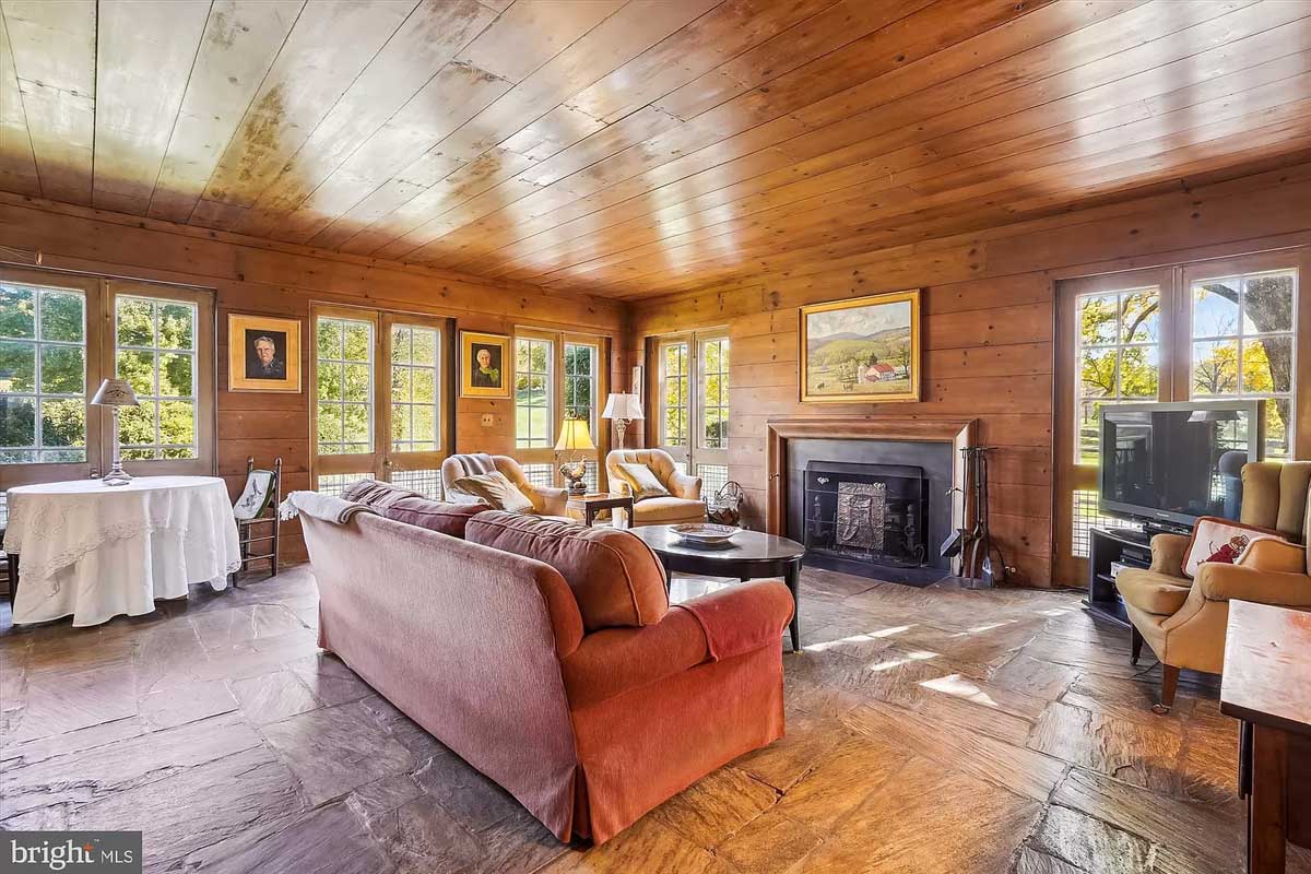 family room with stone floors and wood-paneled walls