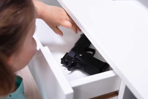 child reaching for gun in drawer