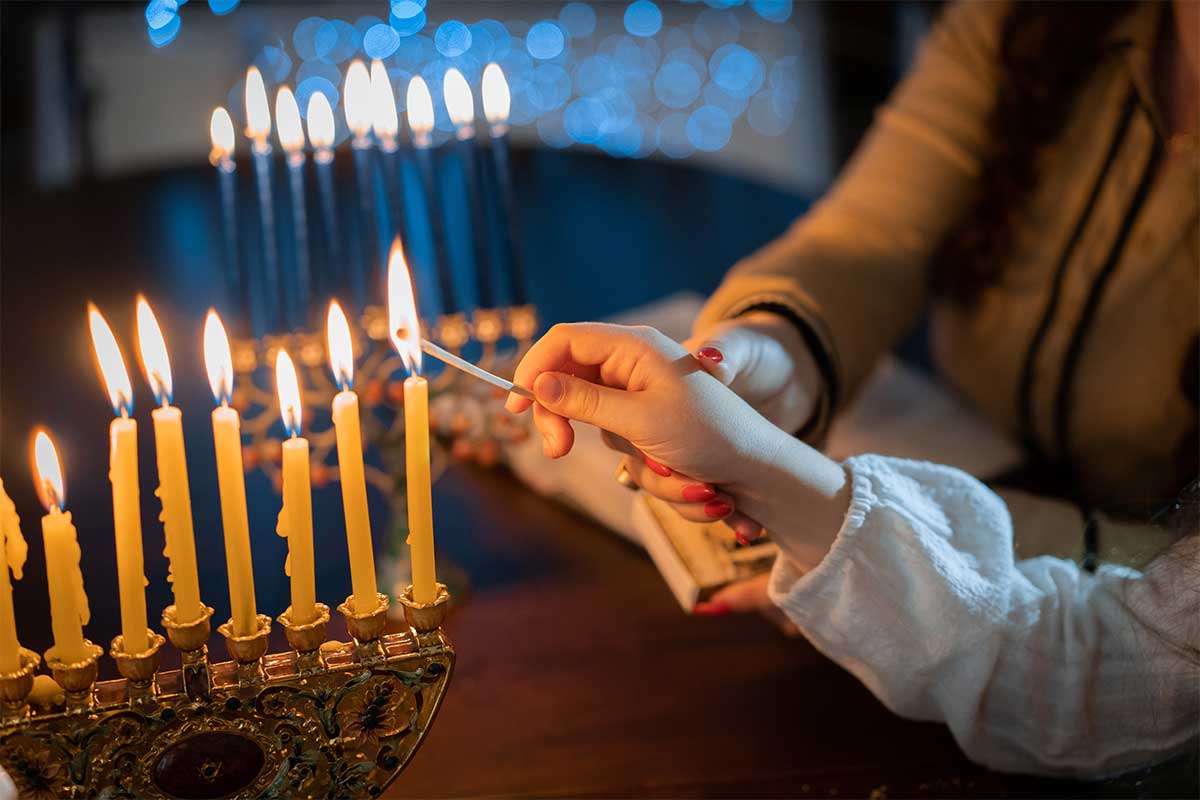 child lighting the menorah