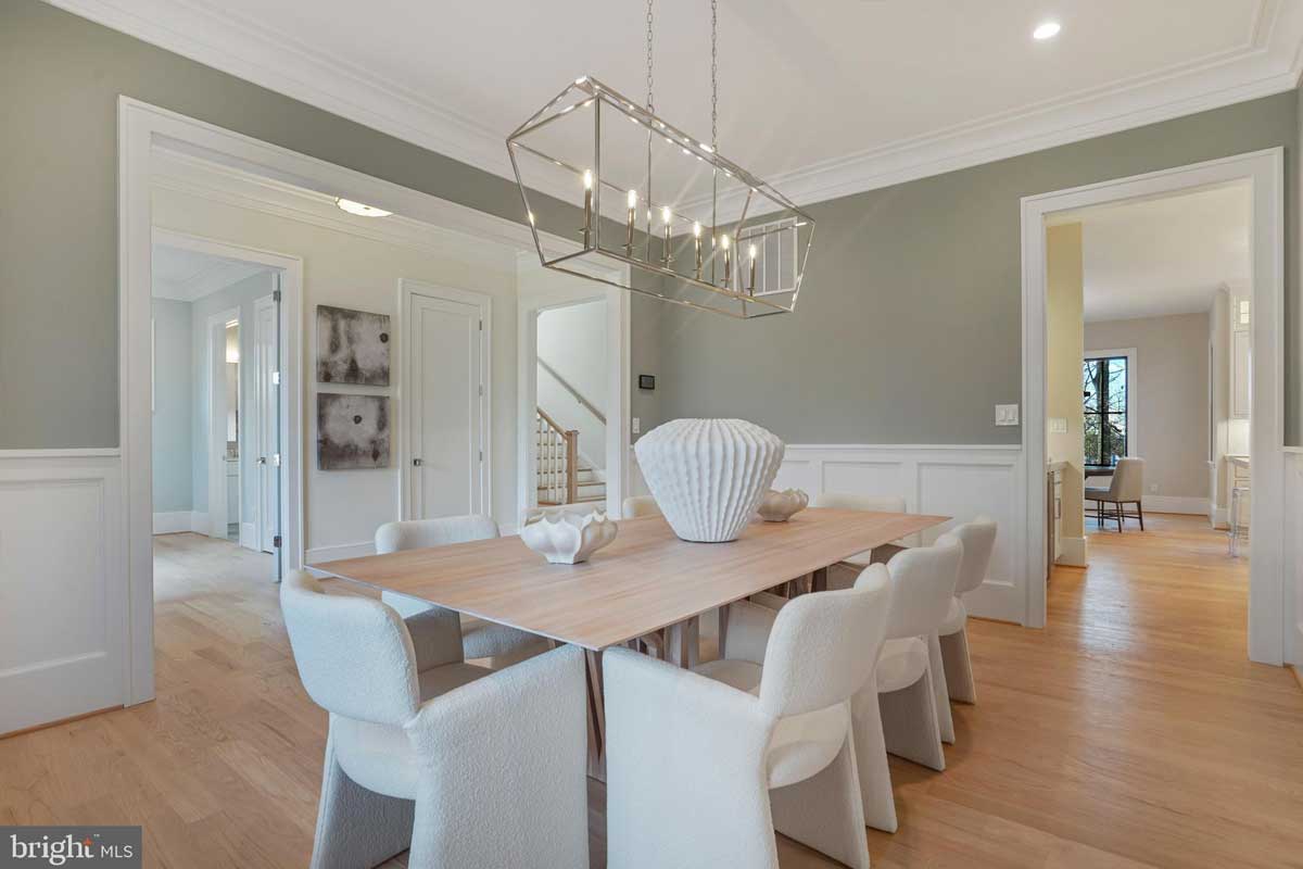 dining room with sage green walls and light wood floors
