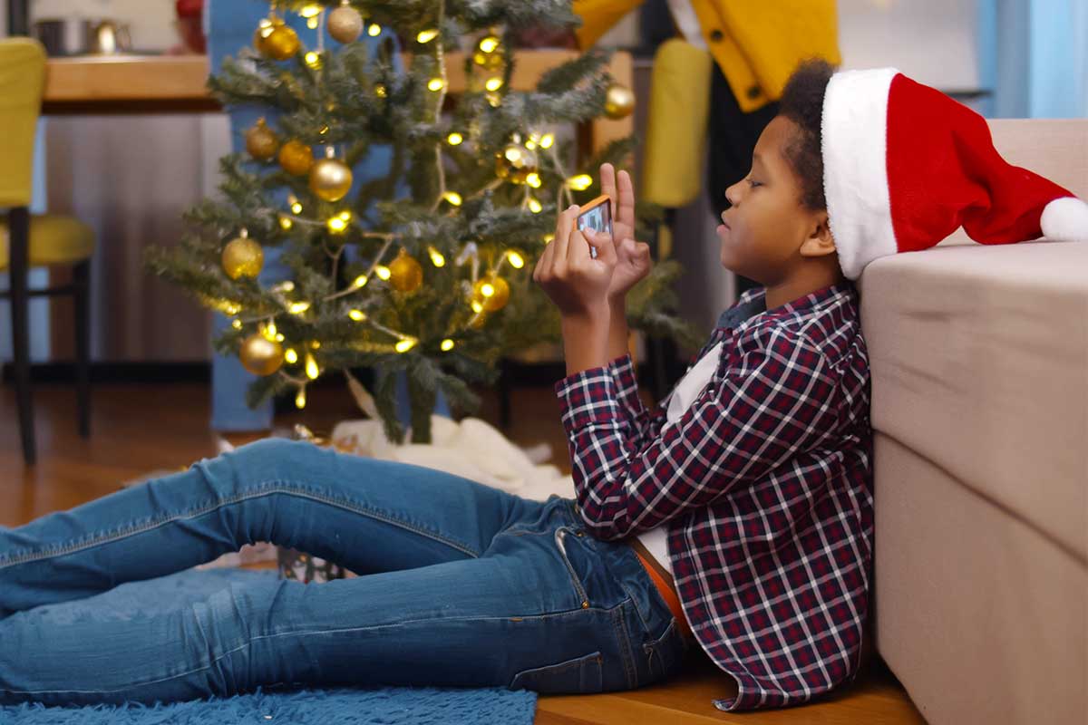 child playing with smartphone during christmas