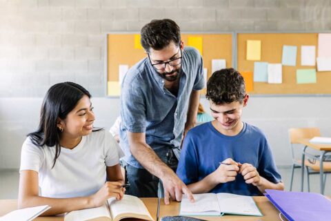 tutor helping two high school students