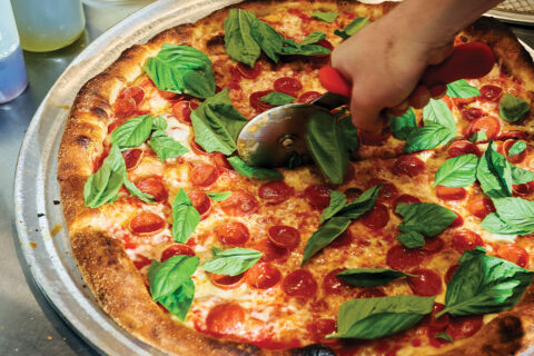 Person slicing pizza