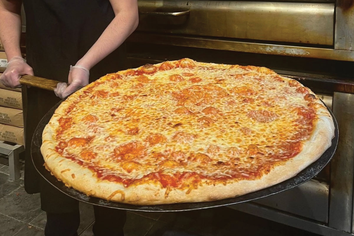 Large pizza coming out of pizza oven