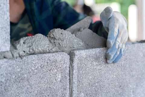 Person laying cement bricks