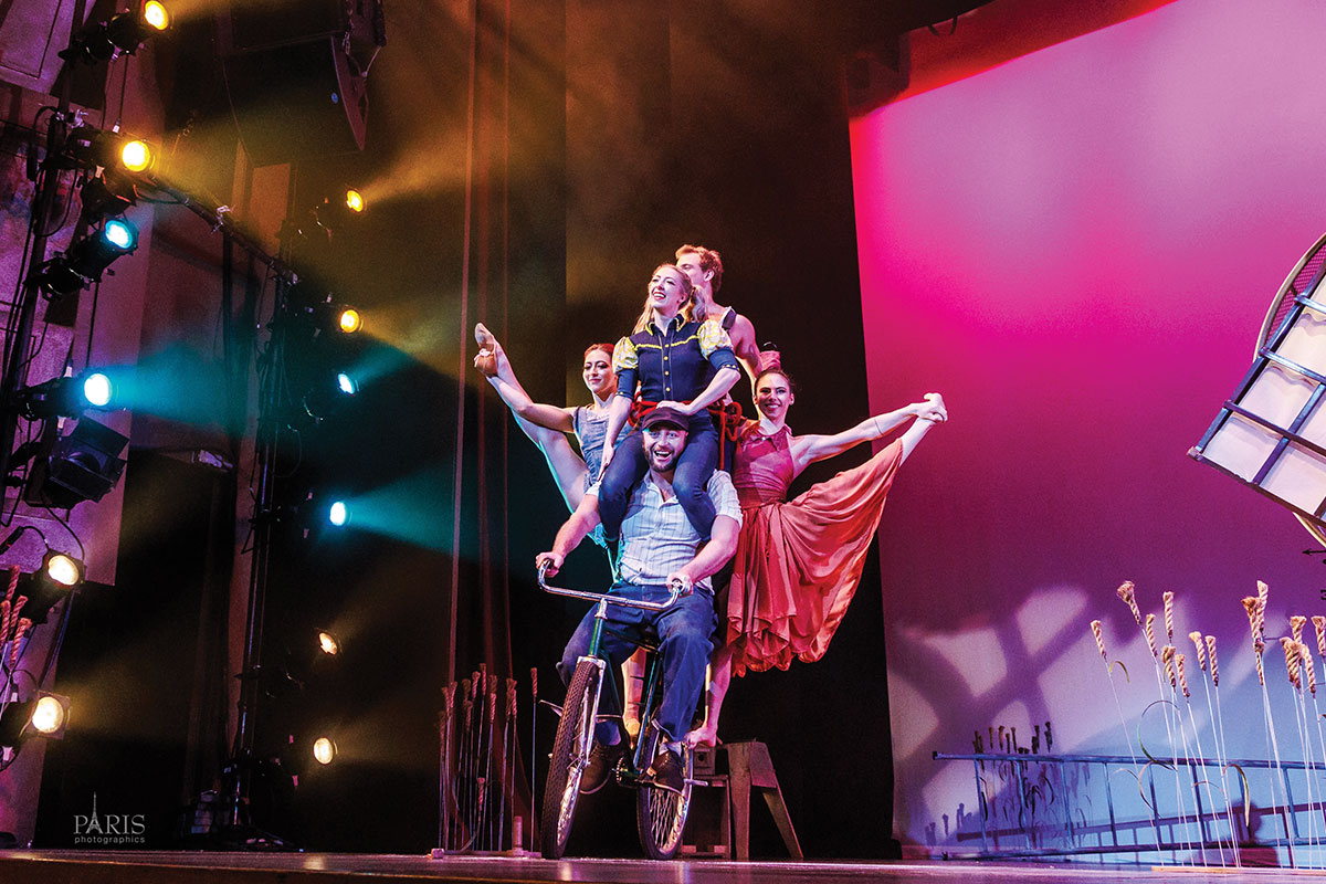 Performers balancing on bicycle on stage
