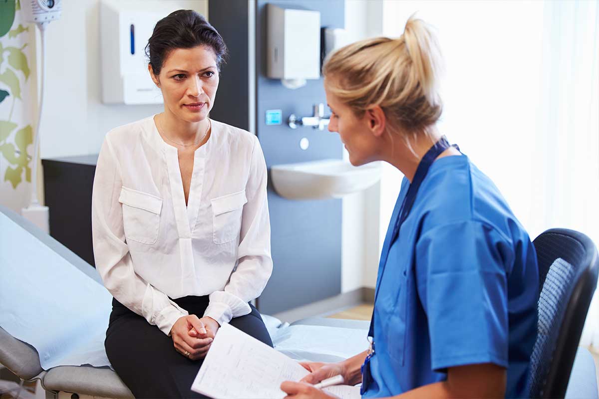 female doctor talking to female patient in exam room