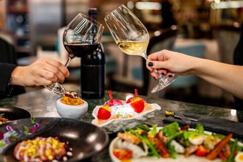man and woman toasting wine glasses