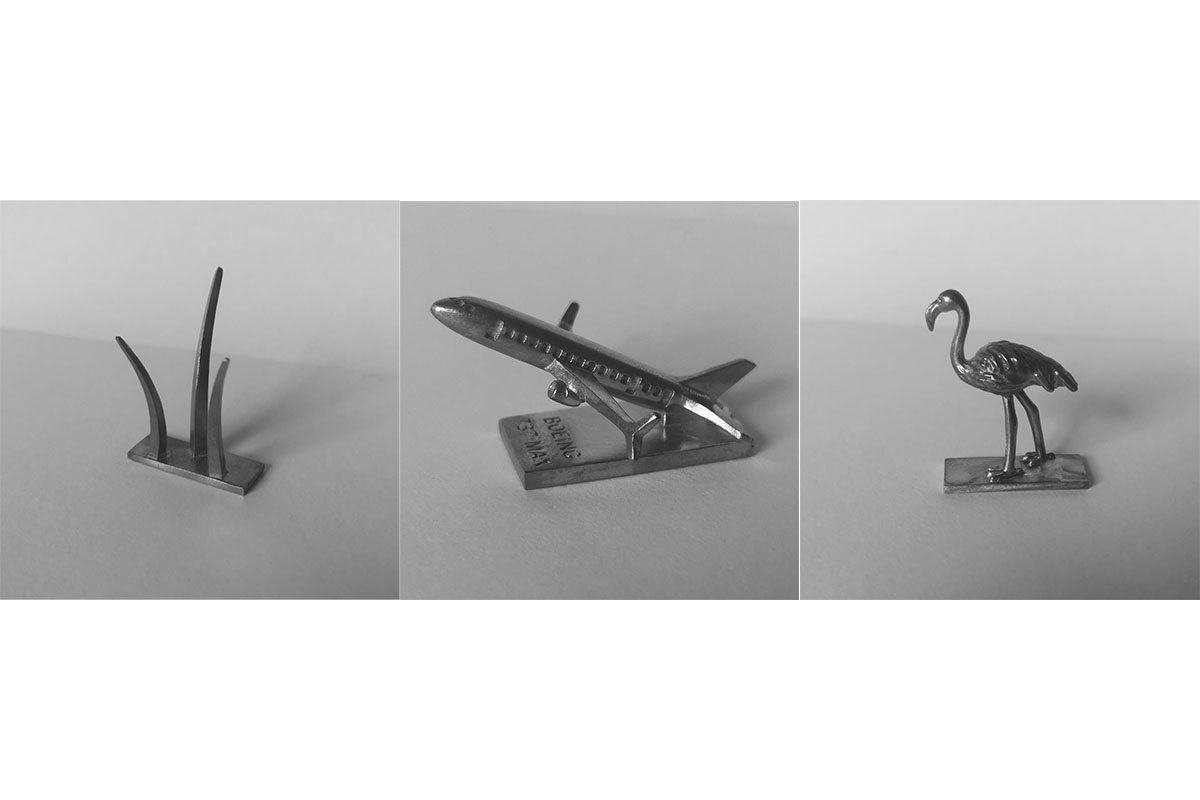 Arlingtonopoly pewter pieces shaped like memorial, airplane, and flamingo