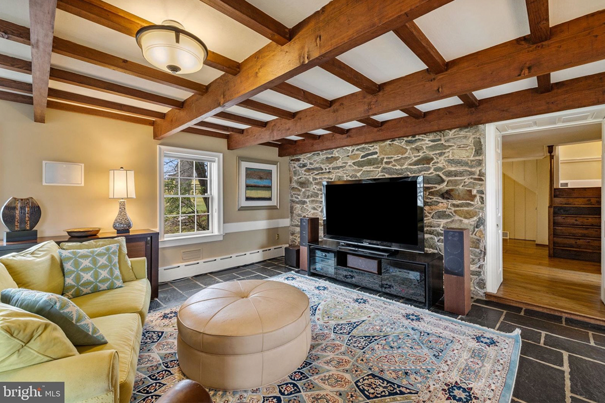 room with stone accent wall and wood beams
