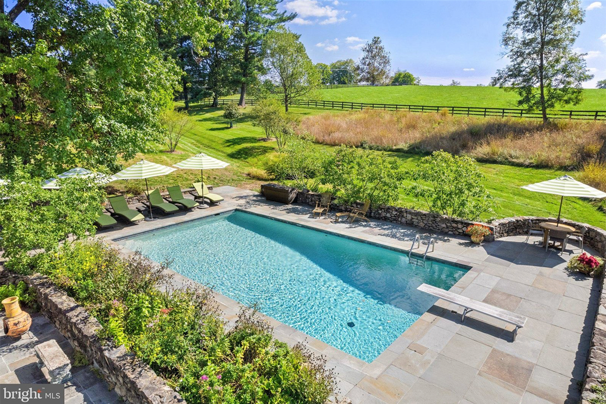 in-ground pool with diving board and lounge area