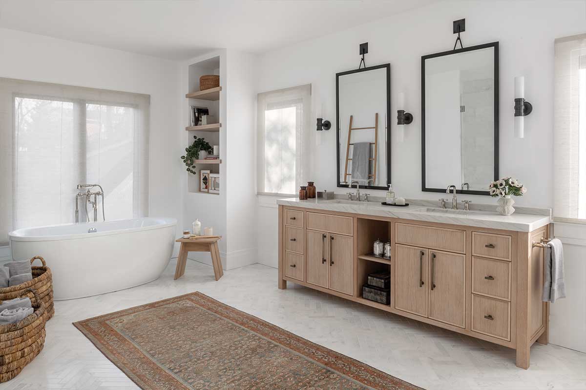 white bathroom with soaking tub and natural wood vanity