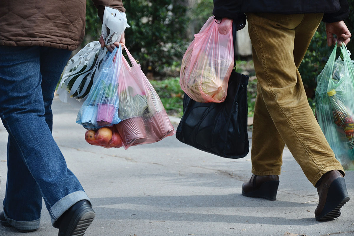 People carrying groceries in plastic bags