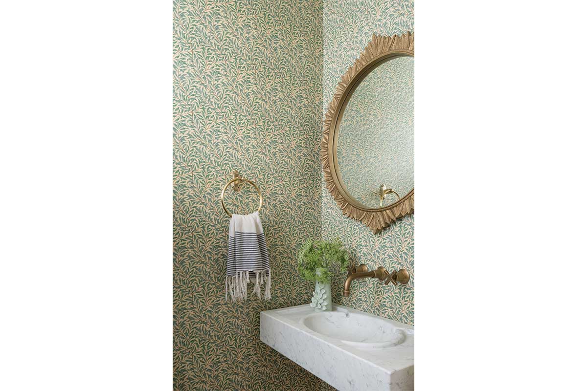 bathrrom with green and yellow patterned wallpaper and gold accents