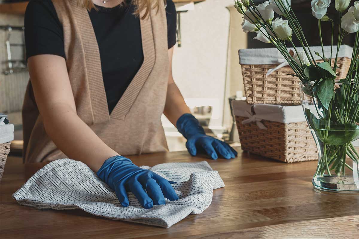 woman dusting counter with cloth