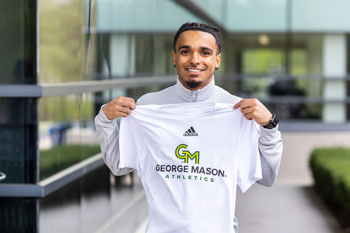 Student displays shirt with new GMU logo